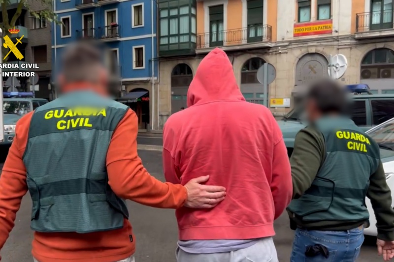 Dos agentes de la guardia civil llevando a un detenido Dos agentes de la guardia civil llevando a un detenido