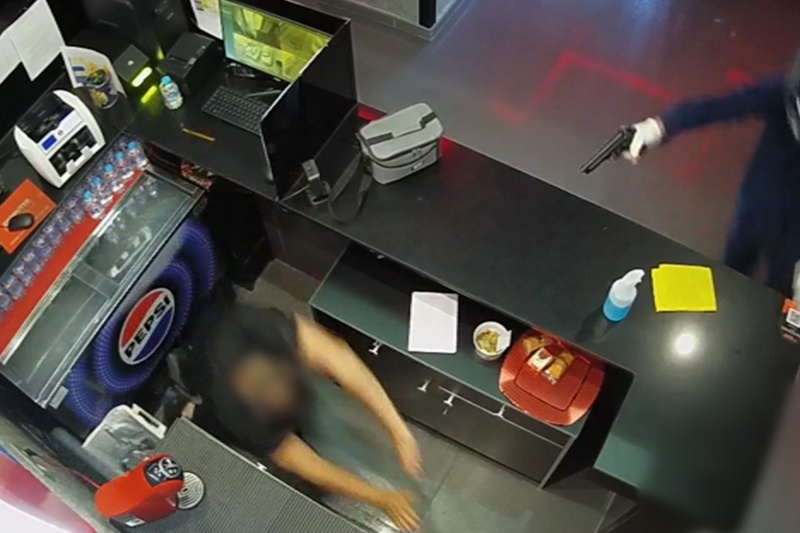 Atracador del salón de juegos apuntando a un empleado
