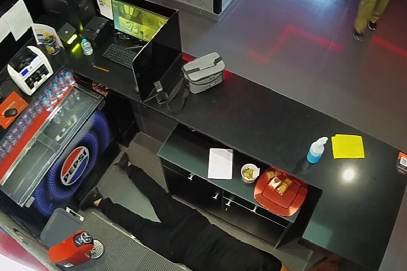 Empleado del salón de juegos tumbado boca abajo en el suelo