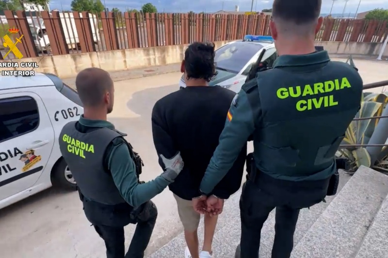 Dos Guardias Civiles custodian a un detenido antes de introducirlo en un coche patrulla Dos Guardias Civiles custodian a un detenido antes de introducirlo en un coche patrulla