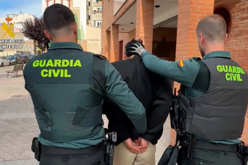 Dos Guardias Civiles custodian a un detenido antes de introducirlo en un coche patrulla Dos Guardias Civiles custodian a un detenido antes de introducirlo en un coche patrulla