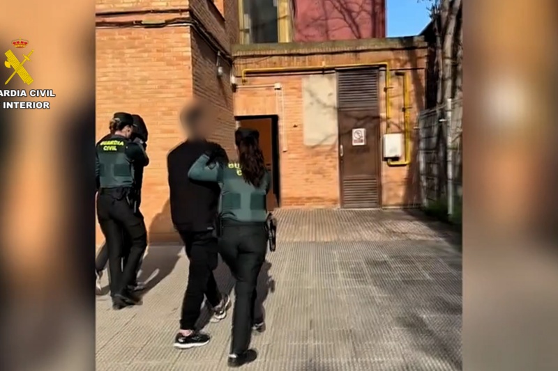 Dos agentes deteniendo a dos personas Dos agentes deteniendo a dos personas