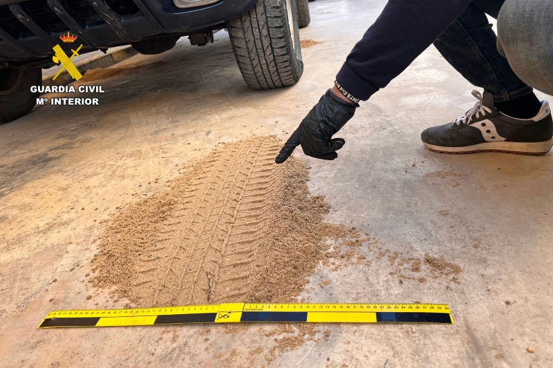 Guardia civil tomando muestras de huellas de las ruedas de un coche Guardia civil tomando muestras de huellas de las ruedas de un coche