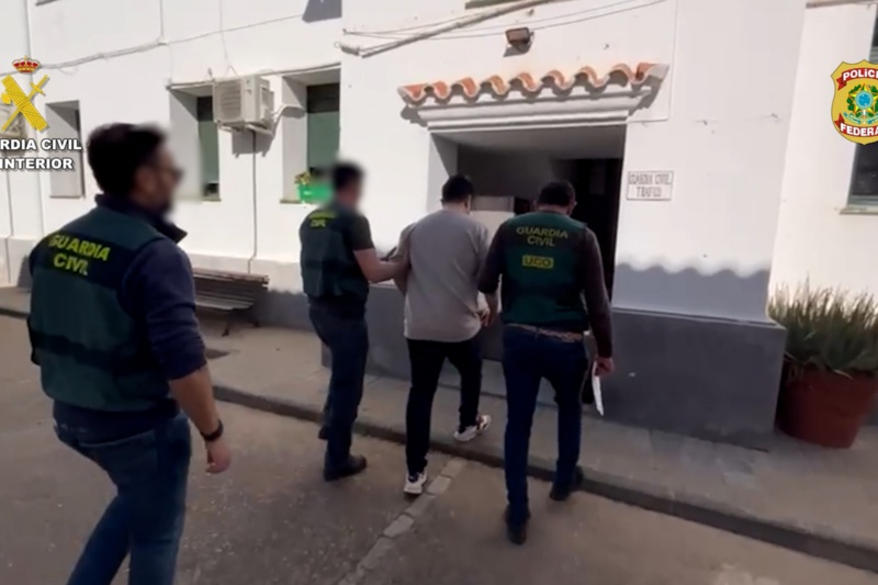 Guardias civiles acompañando a un detenido Guardias civiles acompañando a un detenido