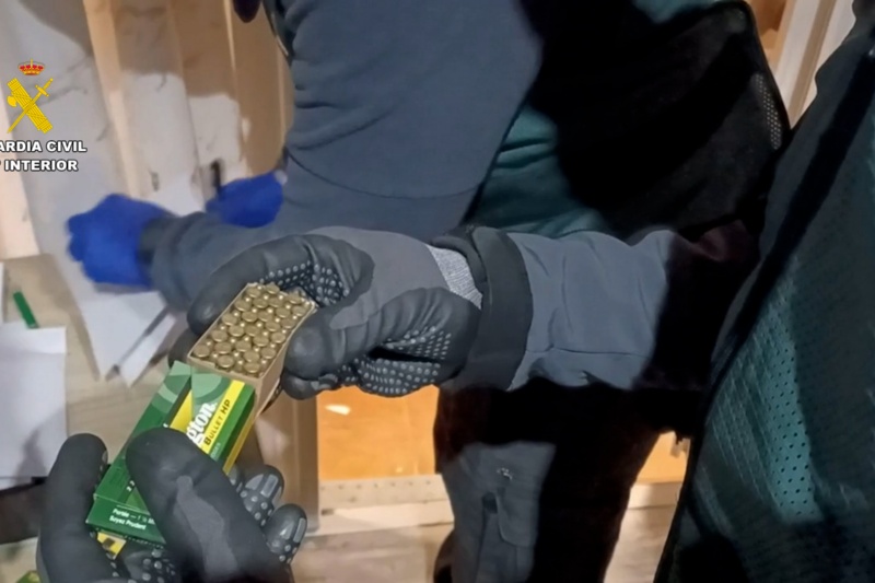 Agentes de la guardia civil durante el registro del domicilio de uno de los detenidos por blanqueo de drogas con un munición intervenida