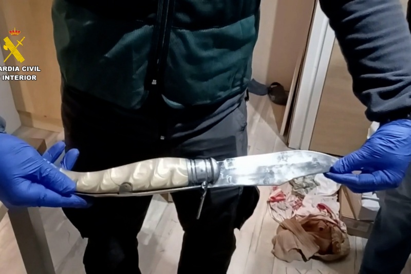 Agentes de la guardia civil durante el registro del domicilio de uno de los detenidos por blanqueo de drogas con una navaja intervenida