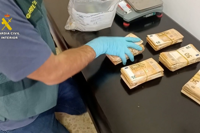 Agentes de la guardia civil durante el registro del domicilio de uno de los detenidos por blanqueo de drogas con fajos de dinero intervenidos