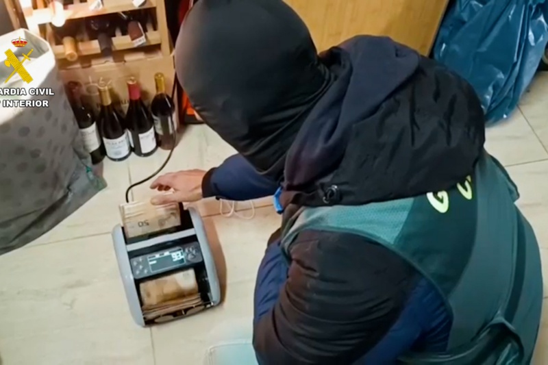 Agente de la guardia civil con una máquina de dinero