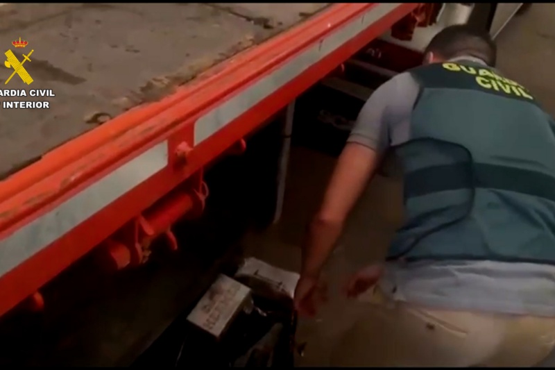 Agente mirando debajo de un camión