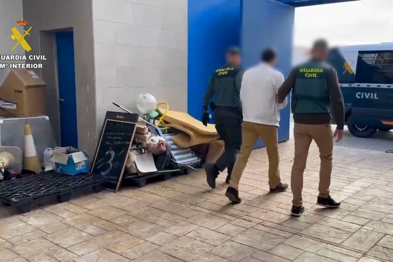 Guardias civiles acompañando a un detenido