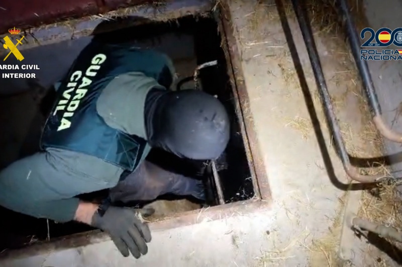 Agente de la guardia civil entrando por una alcantarilla