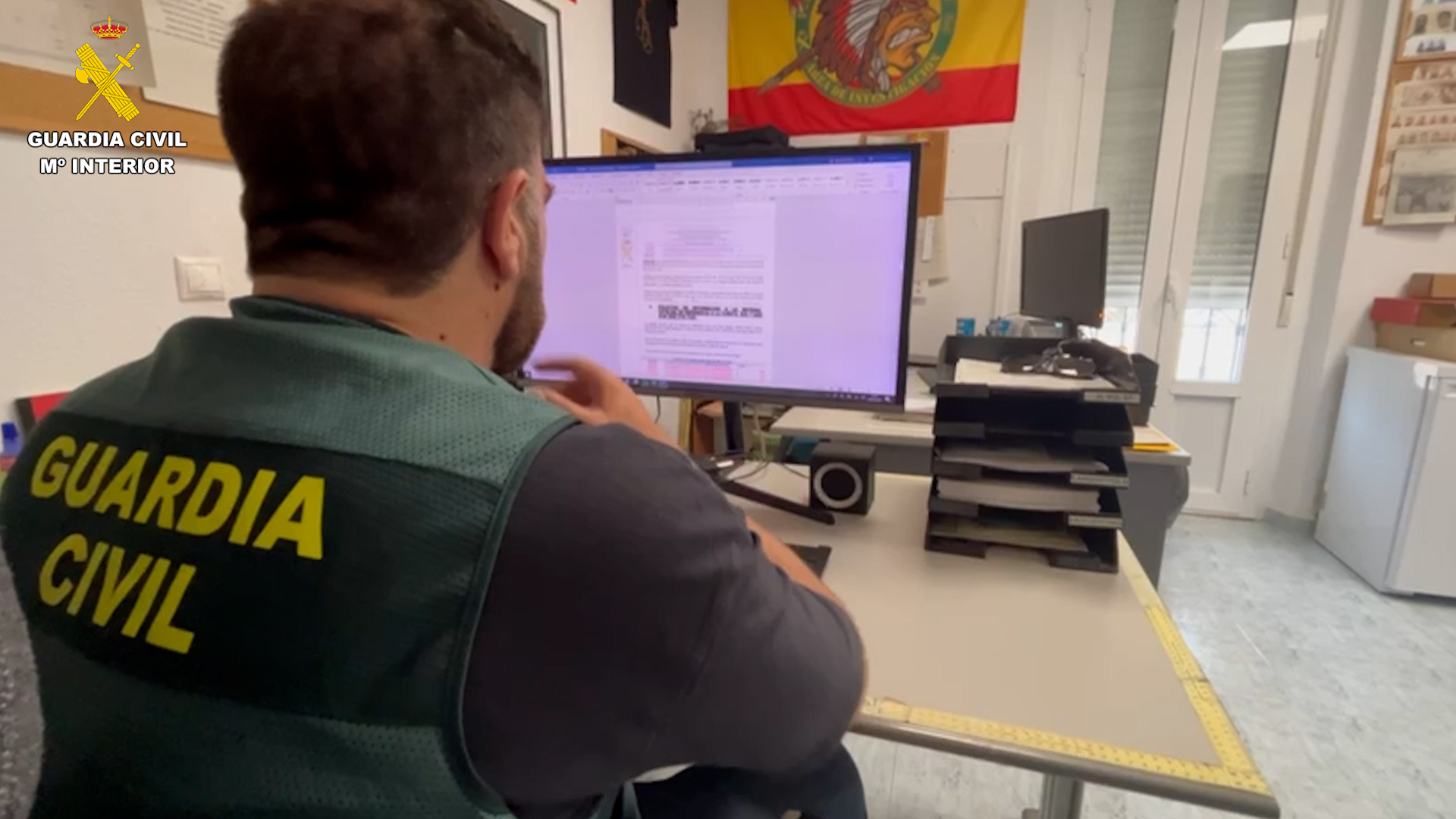 Agente de la guardia civil frente a un ordenador