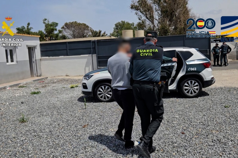Guardia Civil llevando al vehículo a uno de los detenidos