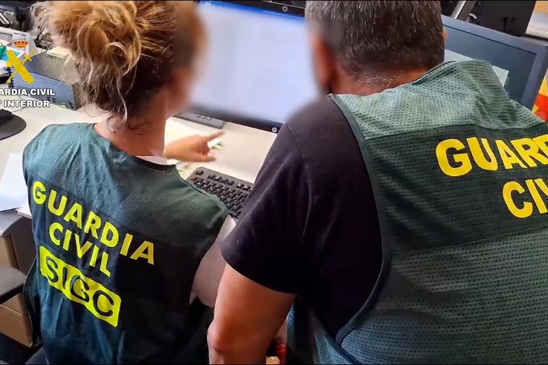 Dos guardias civiles revisan documentación fotográfico intervenida en un ordenador Dos guardias civiles revisan documentación fotográfico intervenida en un ordenador