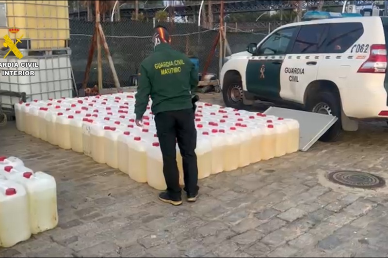 Agente de la guardia civil del servicio marítimo supervisando las garrafas de combustible interceptadas Agente de la guardia civil del servicio marítimo supervisando las garrafas de combustible interceptadas