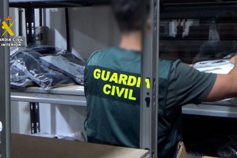 Un guardia civil revisa paquetes de efectos falsificados
