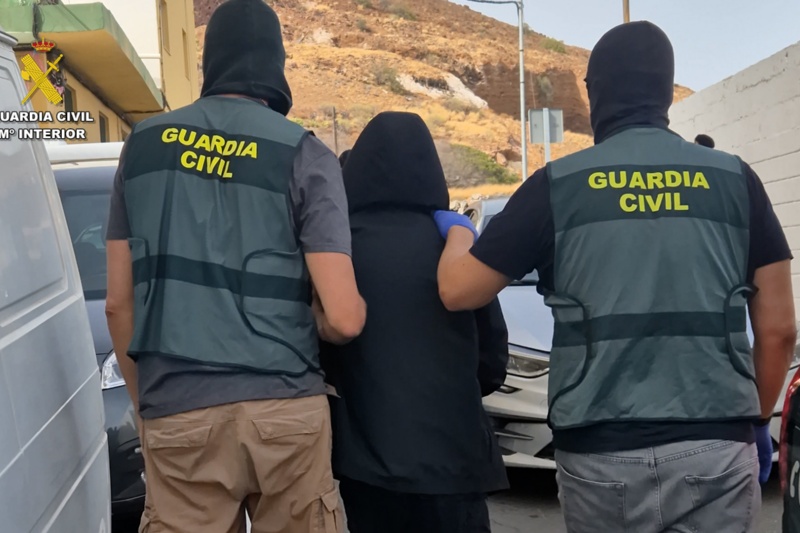 Guardias civiles acompañando a un detenido