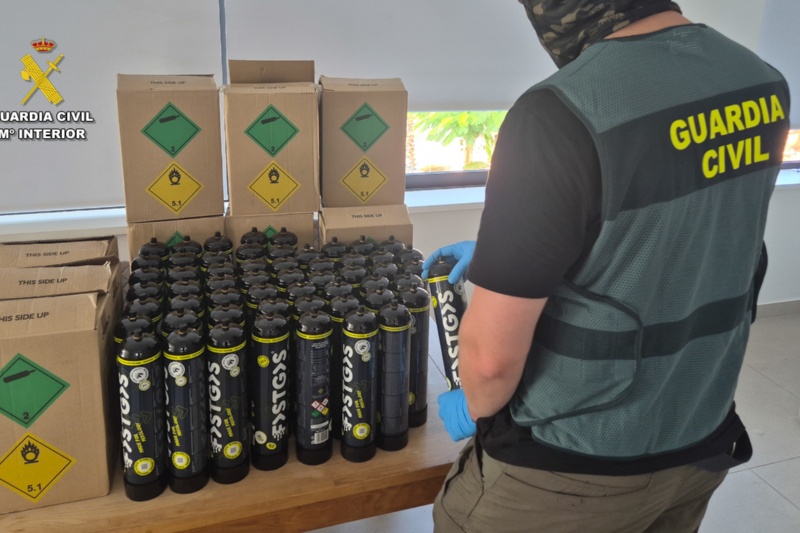 Agente de la Guardia Civil junto a botellas de gas de la risa intervenidas Agente de la Guardia Civil junto a botellas de gas de la risa intervenidas
