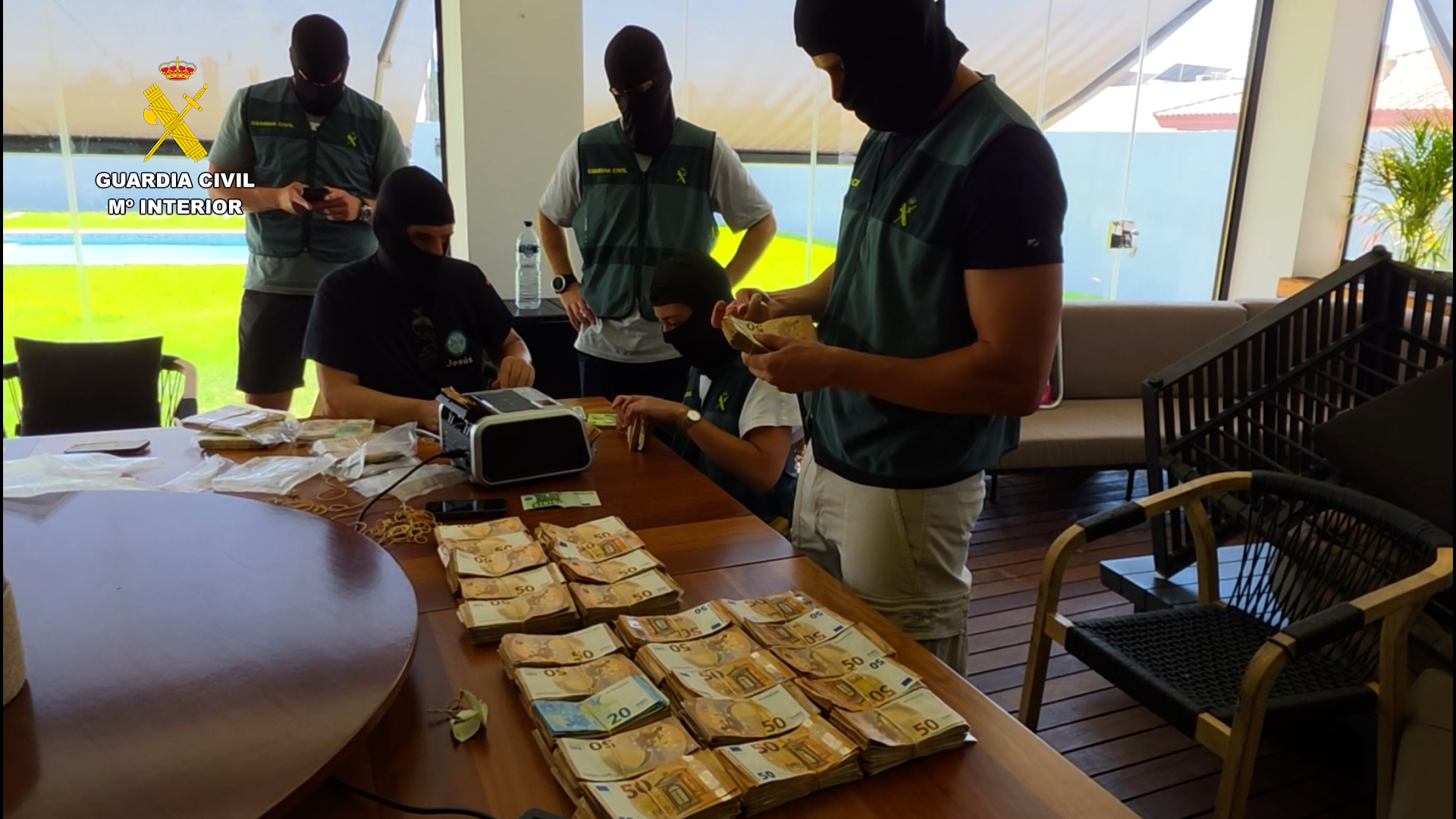 Agentes de la guardia civil durante el registro del domicilio de uno de los detenidos por blanqueo de dinero y haciendo recuento
