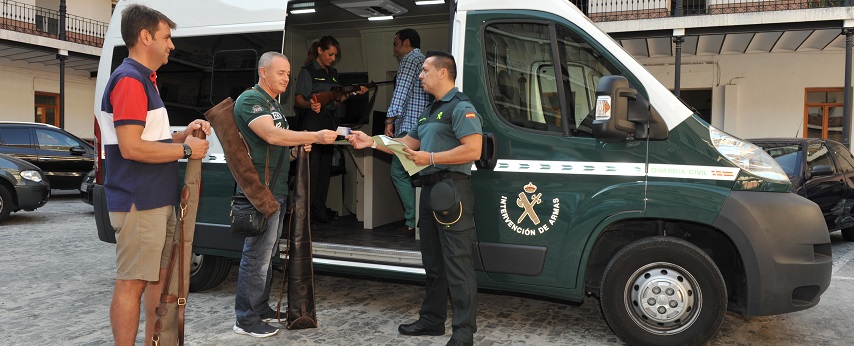 Dos guardias civiles atienden a dos ciudadanos en una intervención de armas móvil