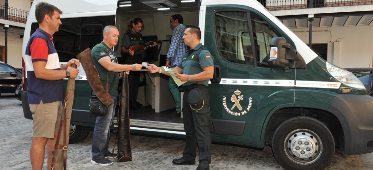 Dos guardias civiles atienden a dos ciudadanos en una intervención de armas móvil