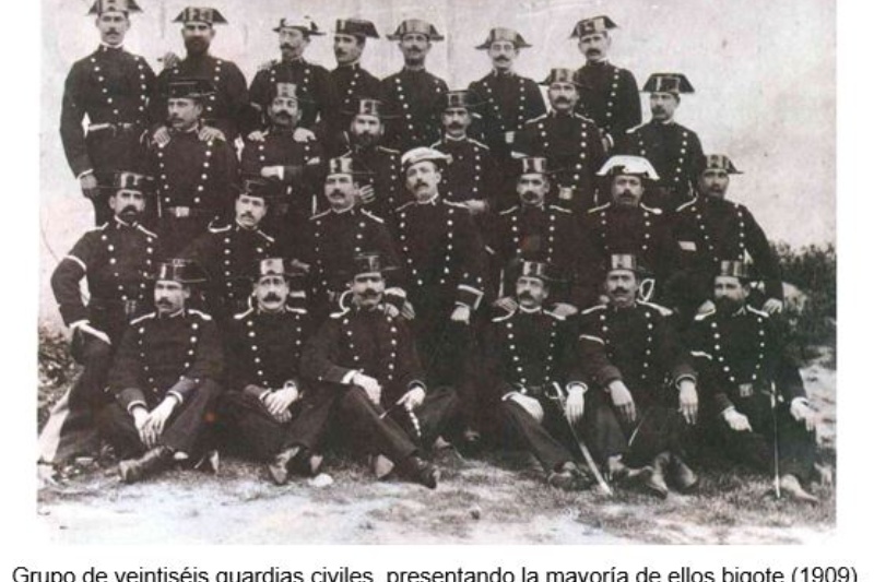 Grupo de veintiséis guardias civiles, presentando la mayoría de ellos bigote (1909). Fuente: Oficina de Relaciones Informativas y Sociales. Guardia Civil.