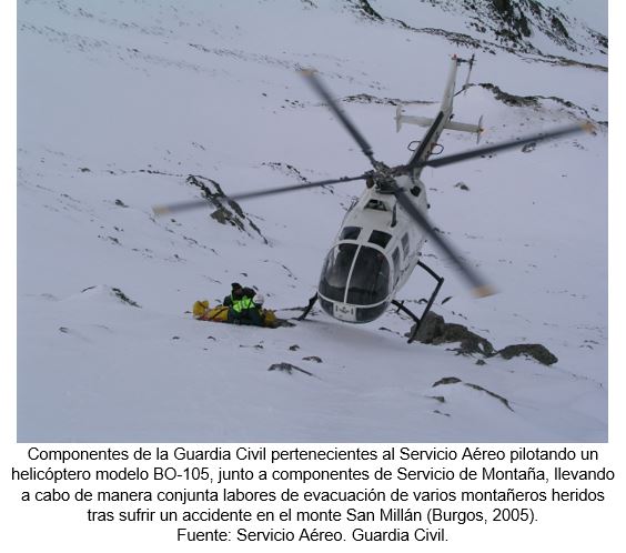 Componentes de la Guardia Civil pertenecientes al Servicio Aéreo pilotando un helicóptero modelo BO-105, junto a componentes de Servicio de Montaña, llevando a cabo de manera conjunta labores de evacuación de varios montañeros heridos tras sufrir un accidente en el monte San Millán (Burgos, 2005). Fuente: Servicio Aéreo. Guardia Civil.