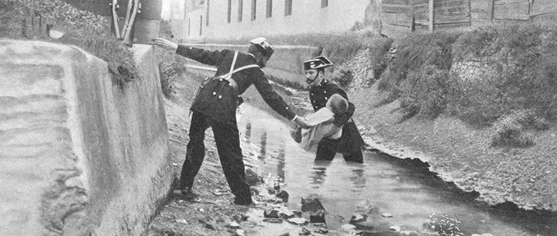Fotografía histórica de la Guardia Civil. Dos guardias civiles rescatan a un niño que se encontraba en un río