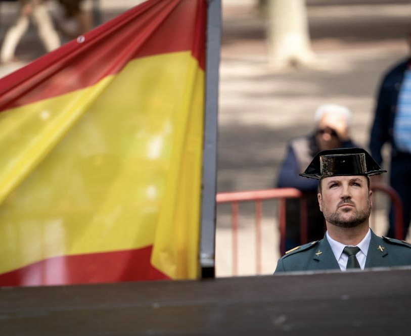 Bandera de España con un guardia civil al fondo